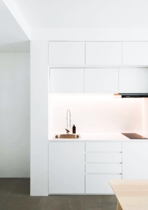 The photo shows the kitchenette in white