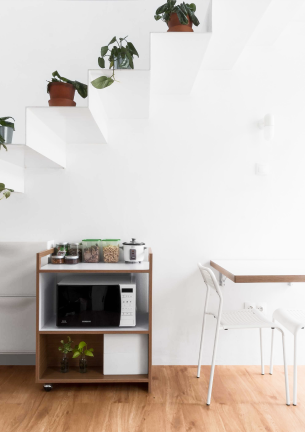 The photo shows the stairs to the top and under the stairs the cabinet and next to the table